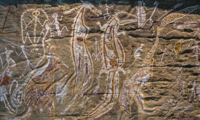 Aboriginal rock art figures on sandstone wall